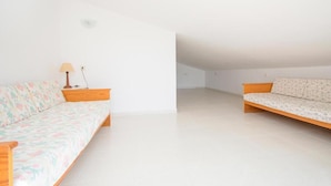 Ein Zimmer mit zwei Sofas, einer Lampe und einem weißen Fliesenboden.