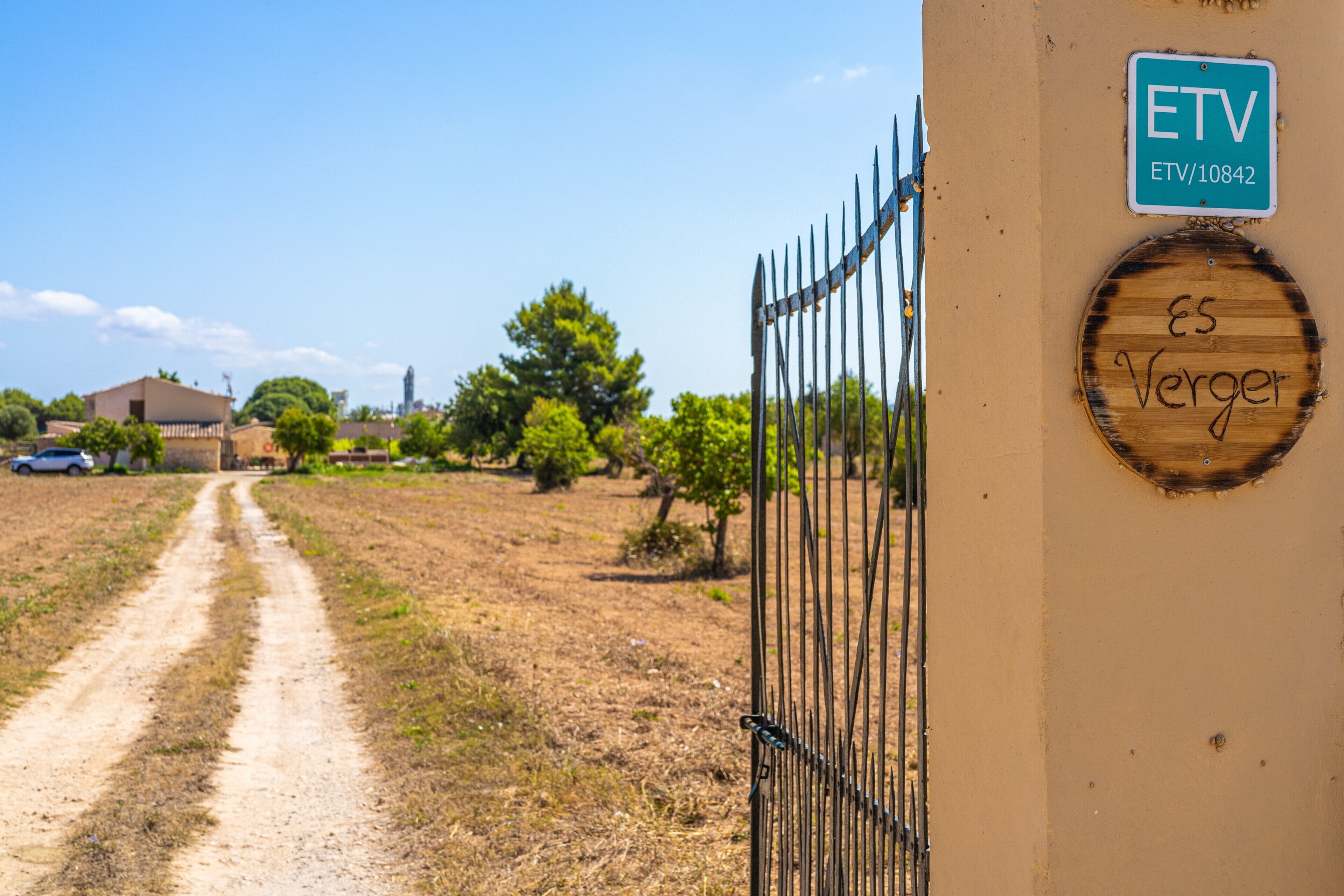 A dirt path leading to a gated area with a sign reading 'ETV' and 'ES Verger'.
