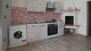 Cocina compacta con lavadora, estufa y microondas.