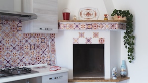 Una cocina con estufa a gas, microondas y salpicadero de azulejos.