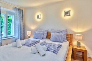 A hotel room with a bed, two bedside tables, and two wall-mounted lights. - Altstadt Apartments Melk - Gartenapartment mit Terrasse Top 4 - Altstadt Apartments Melk (Melk)