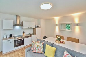 A modern kitchen with white cabinets, a built-in oven, and a microwave. - Altstadt Apartments Melk - Gartenapartment mit Terrasse Top 4 - Altstadt Apartments Melk (Melk)