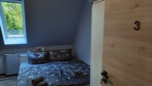A bedroom with a bed, a window, and a wardrobe. - Zimmer 3 - Seenland-oase Reppist (Senftenberg)