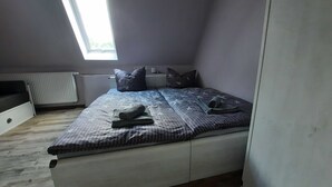 Een slaapkamer met een bed, een raam en een radiator.
