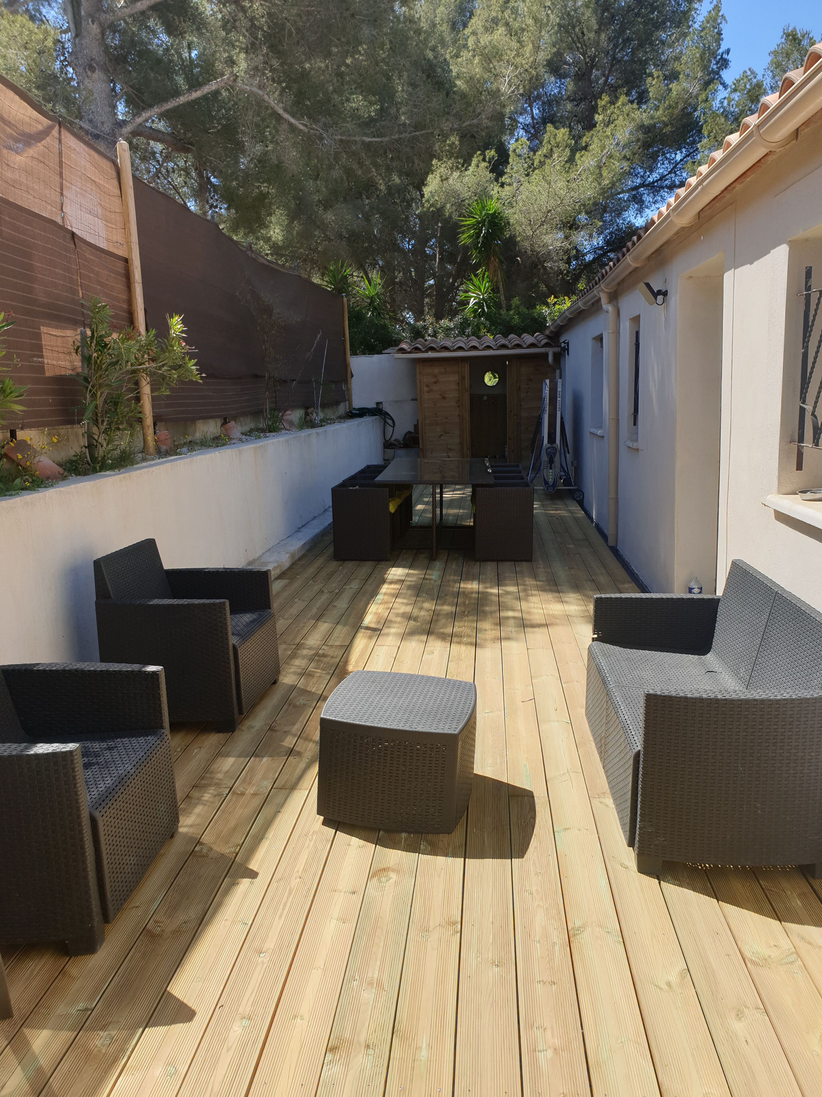 An outdoor patio with wicker furniture and a wooden deck.
