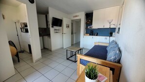 Een knus woongedeelte met kitchenette, een eethoek en een slaapkamer.