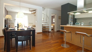 A modern kitchen with a central island, bar stools, and a dining area with a table and chairs. - Villa 2103/39323 (Istria - Pula), 2500m from the beach (Pula)