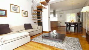 A modern living room with a sofa, coffee table, and a spiral staircase. - Villa 2103/39323 (Istria - Pula), 2500m from the beach (Pula)