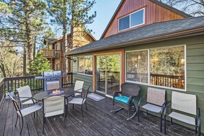 Une terrasse aménagée avec du mobilier d’extérieur, un barbecue et un foyer.