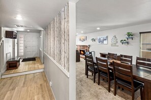 Un intérieur moderne comprenant un coin repas, une cheminée et un escalier.