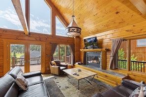 Een chalet inrichting met een open haard, lederen meubels en grote ramen.