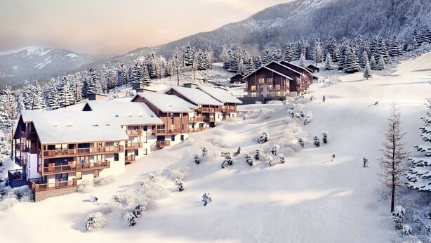 Un centro de esquí cubierto de nieve con varias construcciones tipo chalet, pistas de esquí y un telón de fondo montañoso.