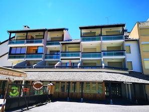 A multi-story hotel with balconies and a restaurant at the ground level.