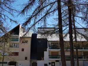 Um edifício de vários andares com design arquitetônico moderno, com varandas e janelas amplas.