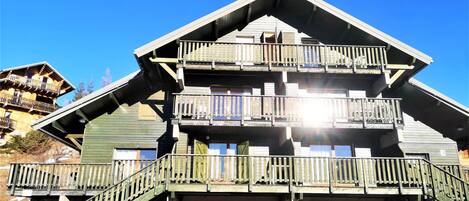 Un edificio de madera de varios pisos, con balcones y una escalera que conduce a los pisos superiores.