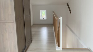 A narrow, wooden-floored hallway with a window at the end. - Idyllisches Ferienhaus in Ostseenähe (Dorf Mecklenburg OT Rambow)