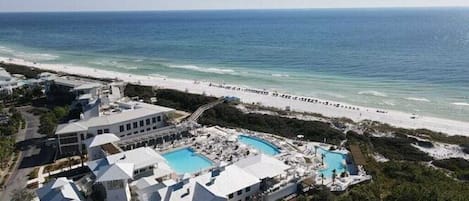 A resort with multiple buildings, a beach, and a swimming pool area.