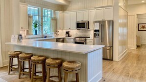 A kitchen with a central island, bar stools, stainless steel appliances, and a large window. - Watercolor Resort|Close To Pool | 6 Pass Golf Cart (Santa Rosa Beach)