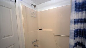 Un bagno con una vasca, una doccetta e un portasciugamani.