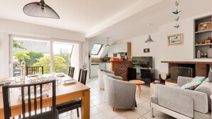 A spacious living area with a dining table, grey sofas, and a fireplace. - 300m beach, lovely house, 6 adults 1 child (Sarzeau)