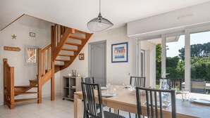 A dining area with a wooden table, chairs, and a staircase. - 300m beach, lovely house, 6 adults 1 child (Sarzeau)