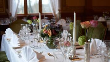 A table set for a formal dining experience with glassware, cutlery, and floral centerpieces.