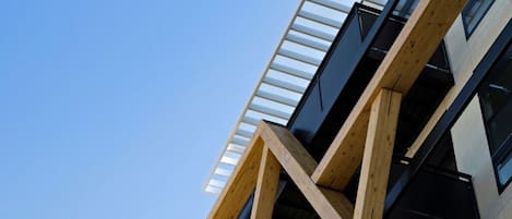 A multi-story building with a distinctive wooden framework and large windows.