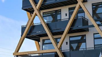 A multi-story building with a unique geometric facade, featuring balconies and large windows.