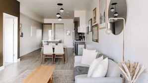 Una sala de estar moderna con un sofá, una mesa de centro y un comedor con sillas y una mesa.