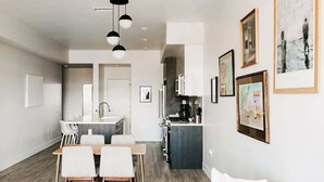 Una cocina moderna con una isla central, sillas de comedor blancas y un diseño minimalista.