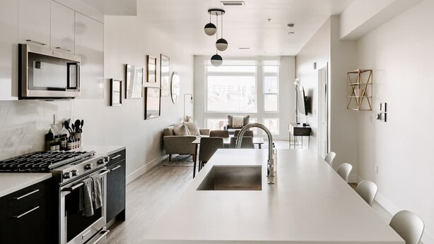 Una cocina moderna con una isla central, electrodomésticos de acero inoxidable y un comedor con vistas.