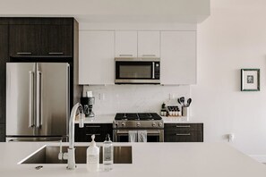 Una cocina moderna con electrodomésticos de acero inoxidable, salpicadero de mármol y un diseño limpio y minimalista.