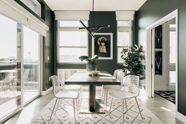 Un espace repas comprenant une table, des chaises, un vase et une plante.