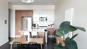 Une cuisine moderne avec des meubles en bois, des appareils en acier inoxydable et un îlot central doté de sièges.