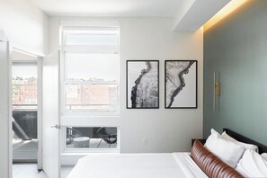 A bedroom with a bed, a window, and two framed artworks on the wall. - New Spacious Modern Loft | Center of LoHi (Denver)