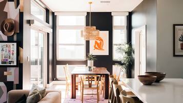 Un comedor moderno con una mesa grande, sillas y una lámpara colgante.