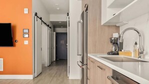 A modern kitchen with a built-in oven, a stainless steel sink, and a coffee machine. - Modern Lifestyle Loft with View | Zuni Lofts (Denver)