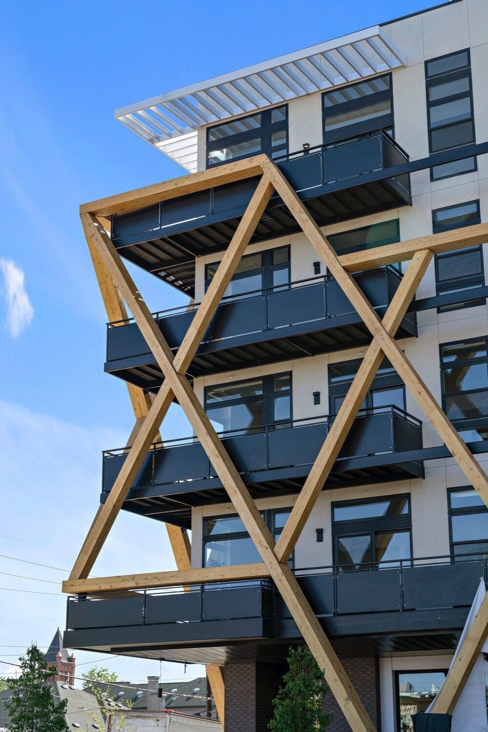 A modern building with a unique geometric facade, featuring balconies and large windows.