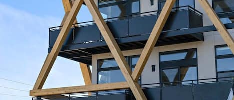 A modern building with a unique geometric facade, featuring balconies and large windows.