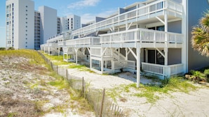 Hotel aan het strand met meerdere balkons en een zandstrand.