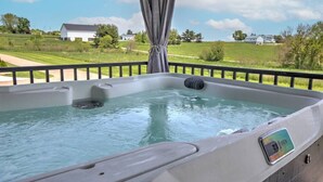 Un bain à remous avec vue sur un paysage verdoyant et des maisons en arrière-plan.