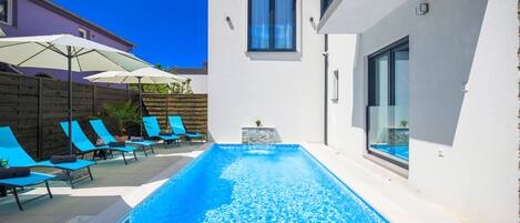 Seasonal outdoor pool, open 10:00 AM to 10:00 PM, pool umbrellas