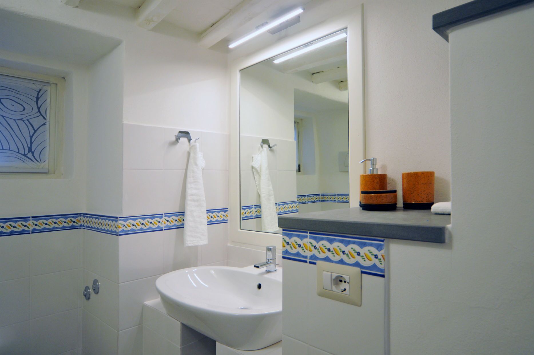 Ein Badezimmer mit Waschbecken, Spiegel und Handtuchhalter.
