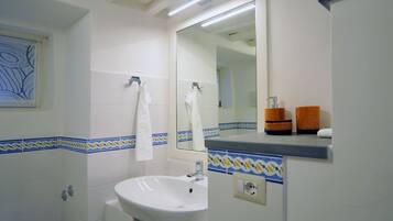 Ein Badezimmer mit Waschbecken, Spiegel und Handtuchhalter.