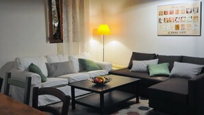 Una sala de estar con dos sofás, una mesa de centro y una lámpara.