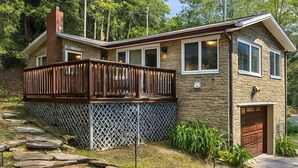 A two-story house with a wooden deck, stone steps, and a garage. - Free 50 Amp EV Charger Modern New, HotTub, A/C, Webber Grill, 2 Decks, FirePit (Fleischmanns)
