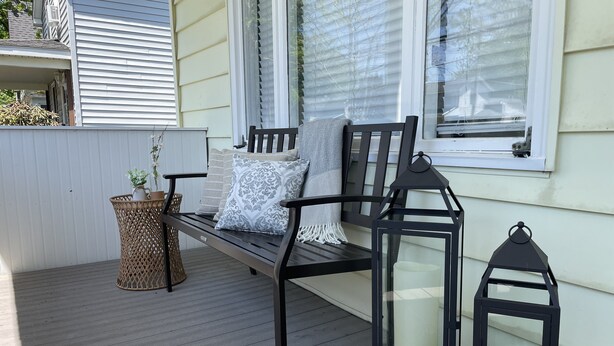 A wooden deck with a bench, two lanterns, and a wicker basket with plants. - Valley View Lakehouse - Fully updated, dog friendly and beautiful lake view! (Mayville, Chautauqua Lake)