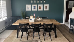 A dining area with a wooden table, black chairs, and a ceiling light fixture. - Valley View Lakehouse - Fully updated, dog friendly and beautiful lake view! (Mayville, Chautauqua Lake)