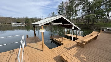 A wooden dock with a covered seating area and a caution sign.