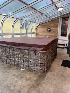 A stone bar area with a glass enclosure, a wooden wall, and a door with a sign. - Lakefront retreat 20 acre property Hocking Hills (Albany)